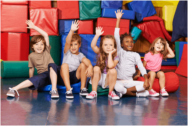 Kids sitting on floor with hands raised