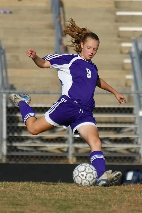 Girl kicking soccer ball