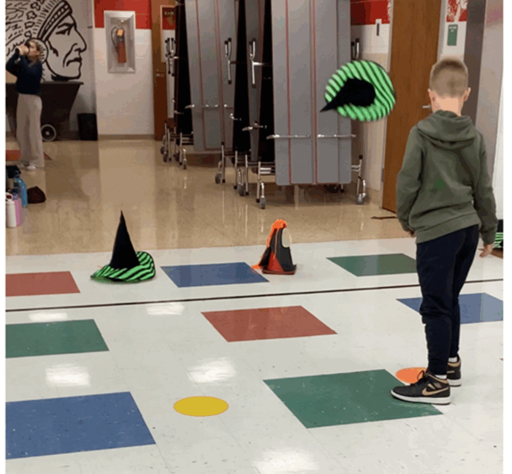 12 Halloween Station Ideas for Elementary PE 1 Student playing Witches' Hat game.