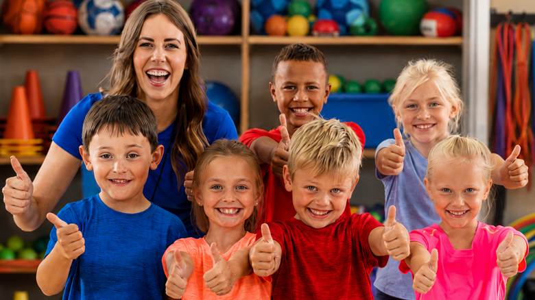 The Complete Elementary PE Equipment List (K–5) 1 PE Teacher and students doing "thumbs up"